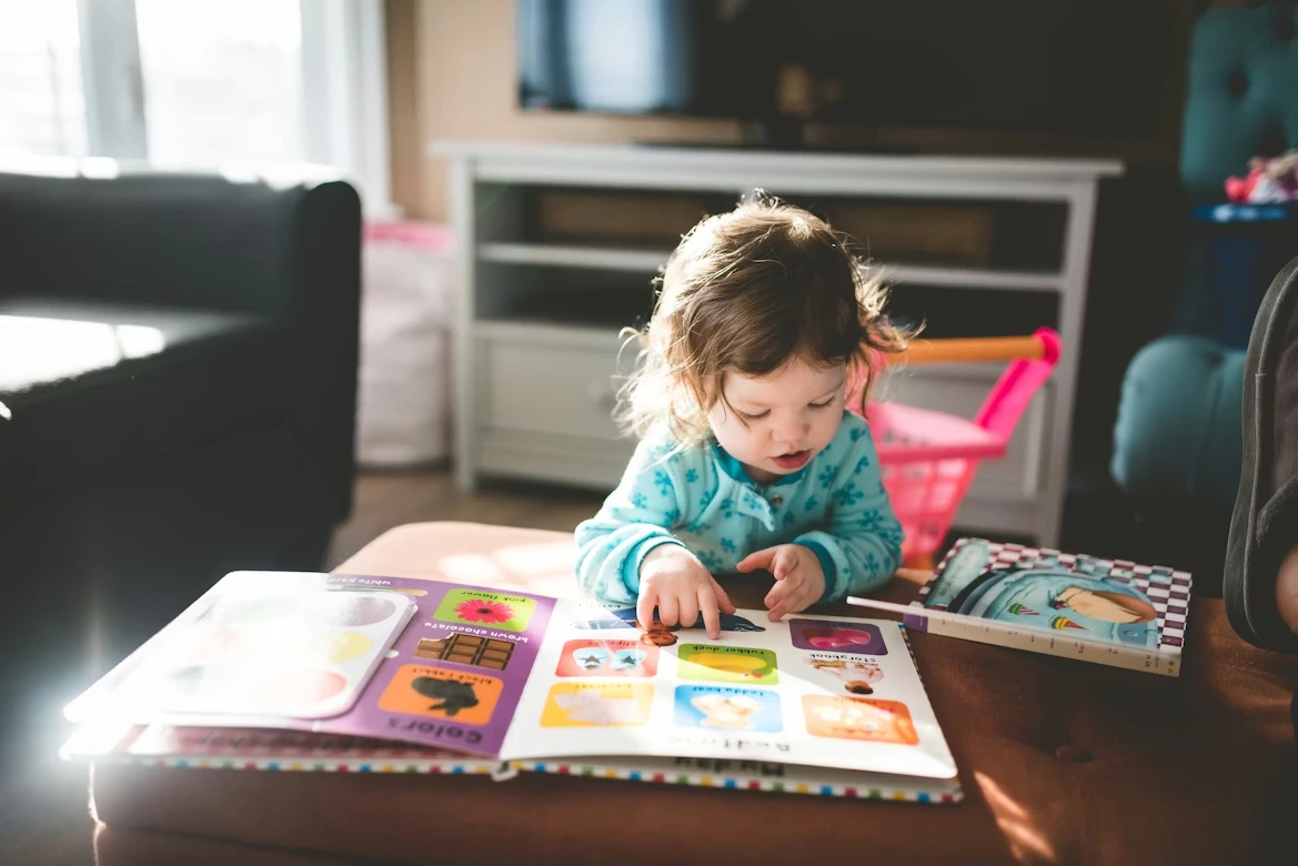 Child reading a book on a cozy couch in natural light
