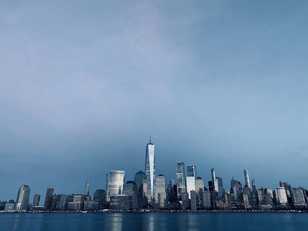 City skyline under gray sky featuring the New York City skyline and One World Trade Center