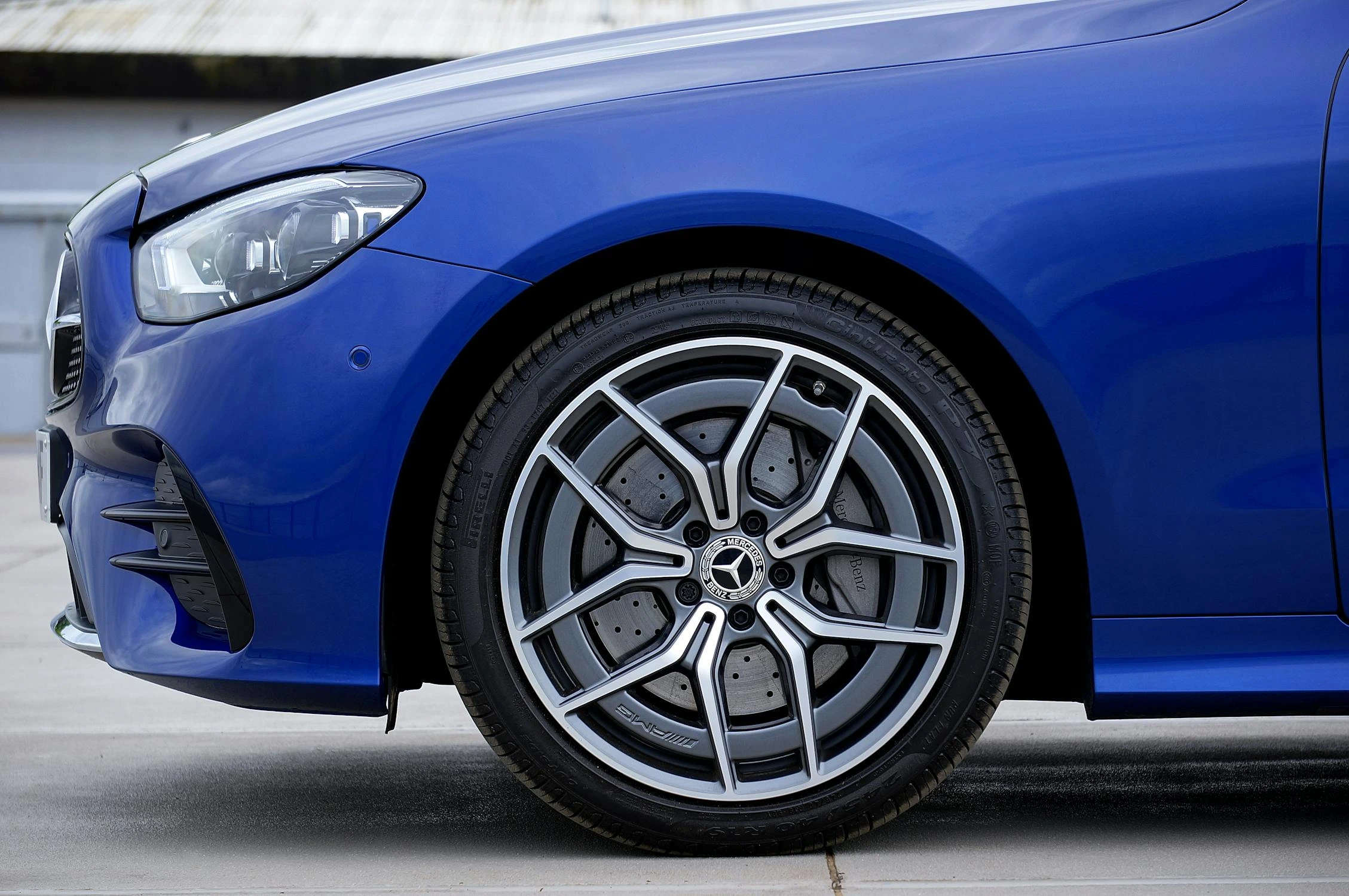 Close-up of a blue car’s alloy wheel and tire