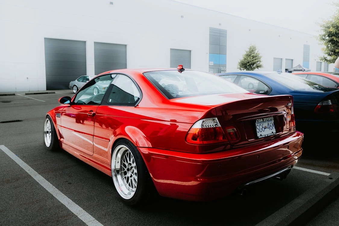 Red sports car parked in an industrial parking lot