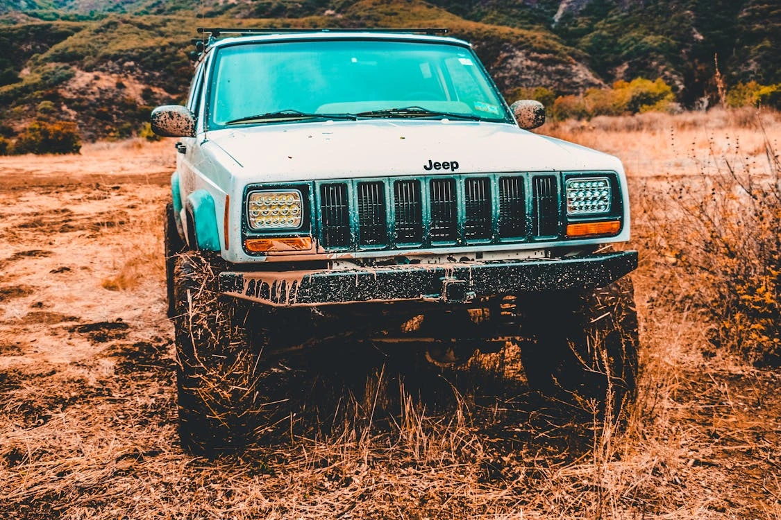 Gray Jeep SUV on a dirt road