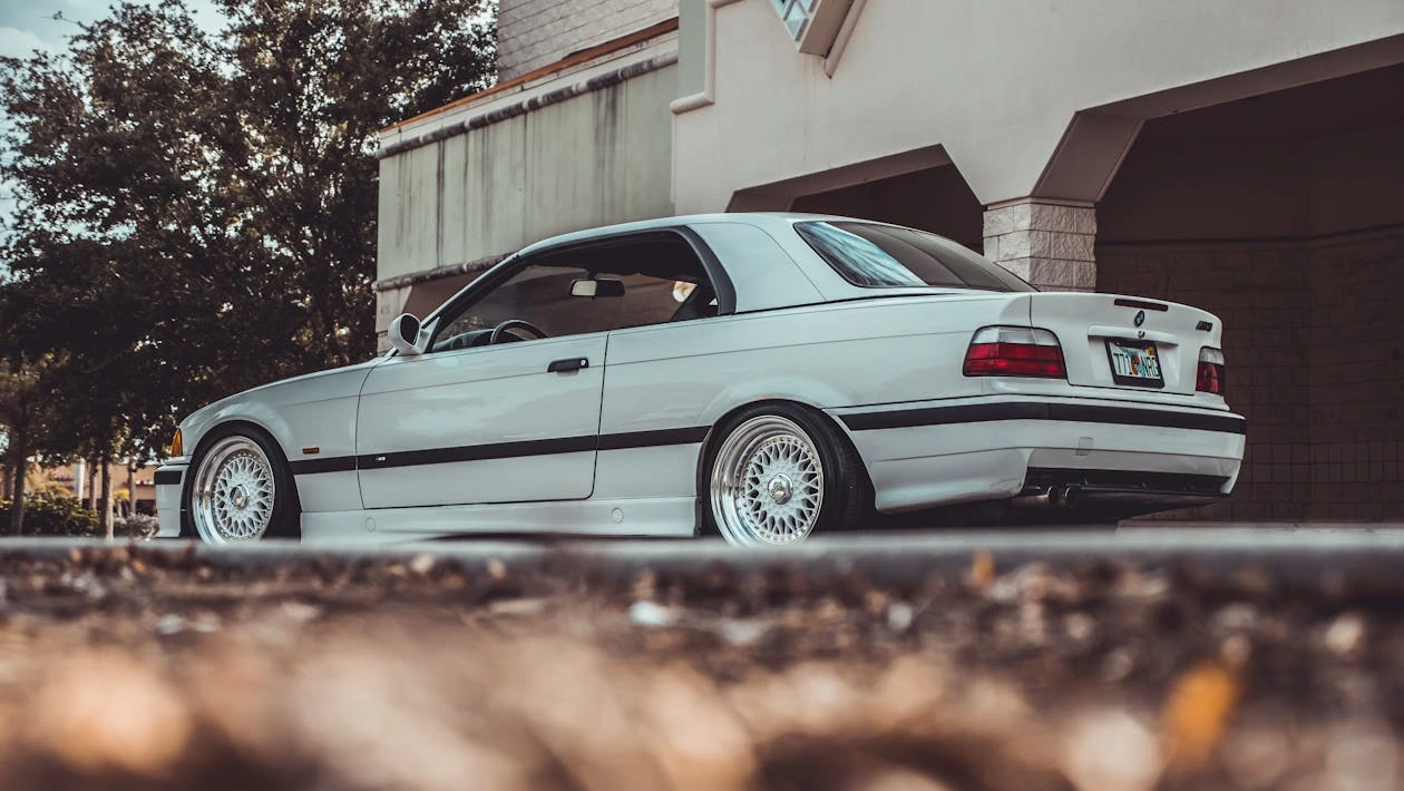Photo of a white car parked outdoors near a building