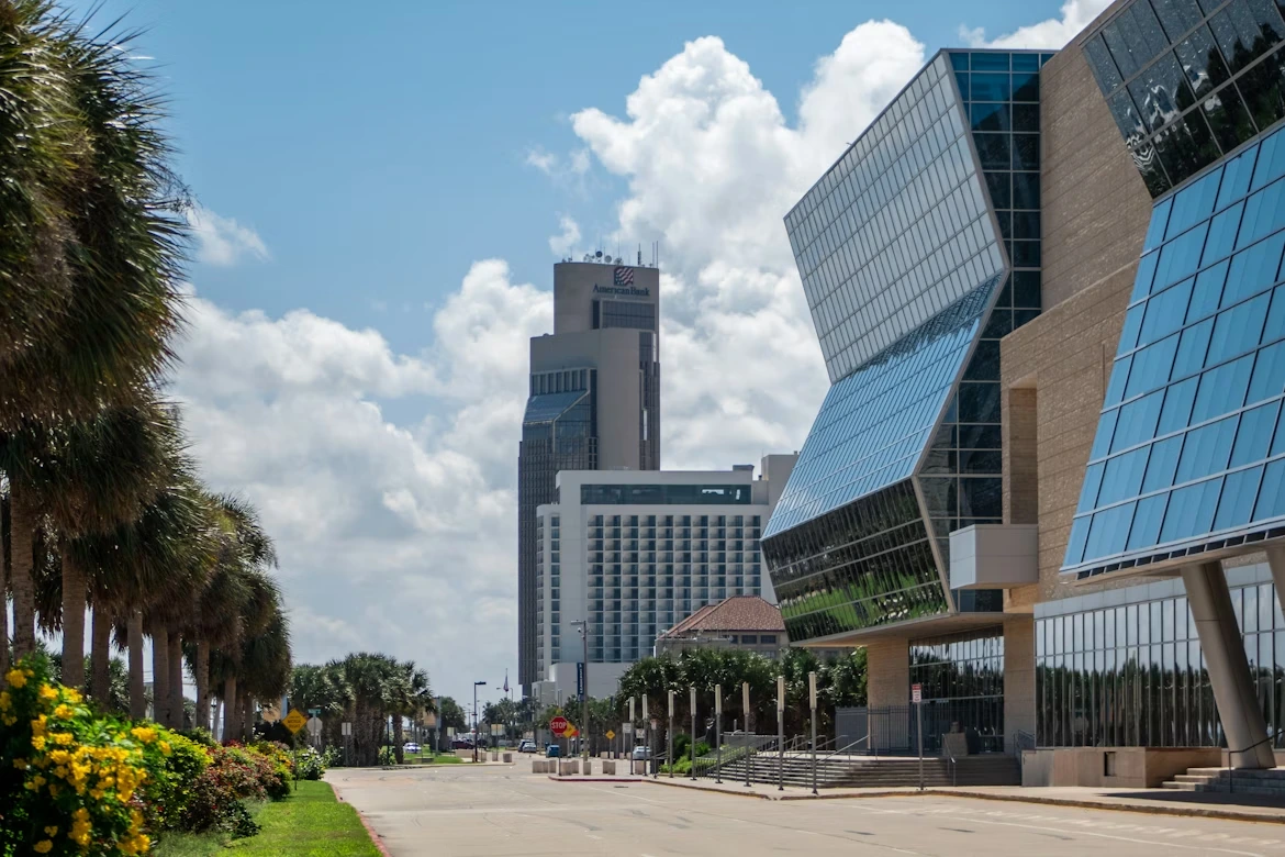 People walking on a sidewalk near high-rise buildings in Corpus Christi, Texas