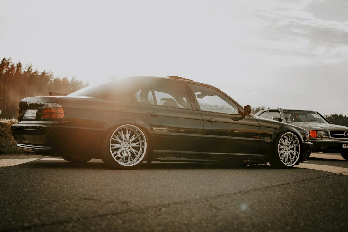 Stylish black sedan parked outdoors at sunset