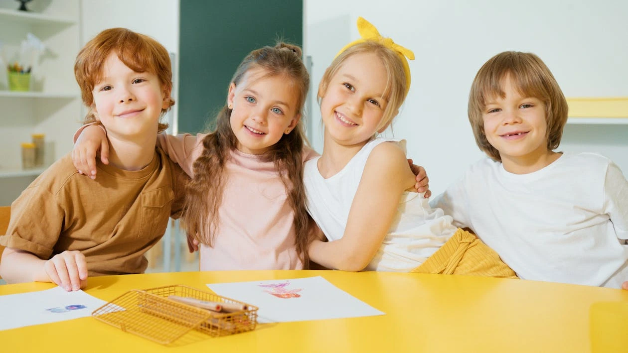 Photo of kids smiling together in a bright classroom setting
