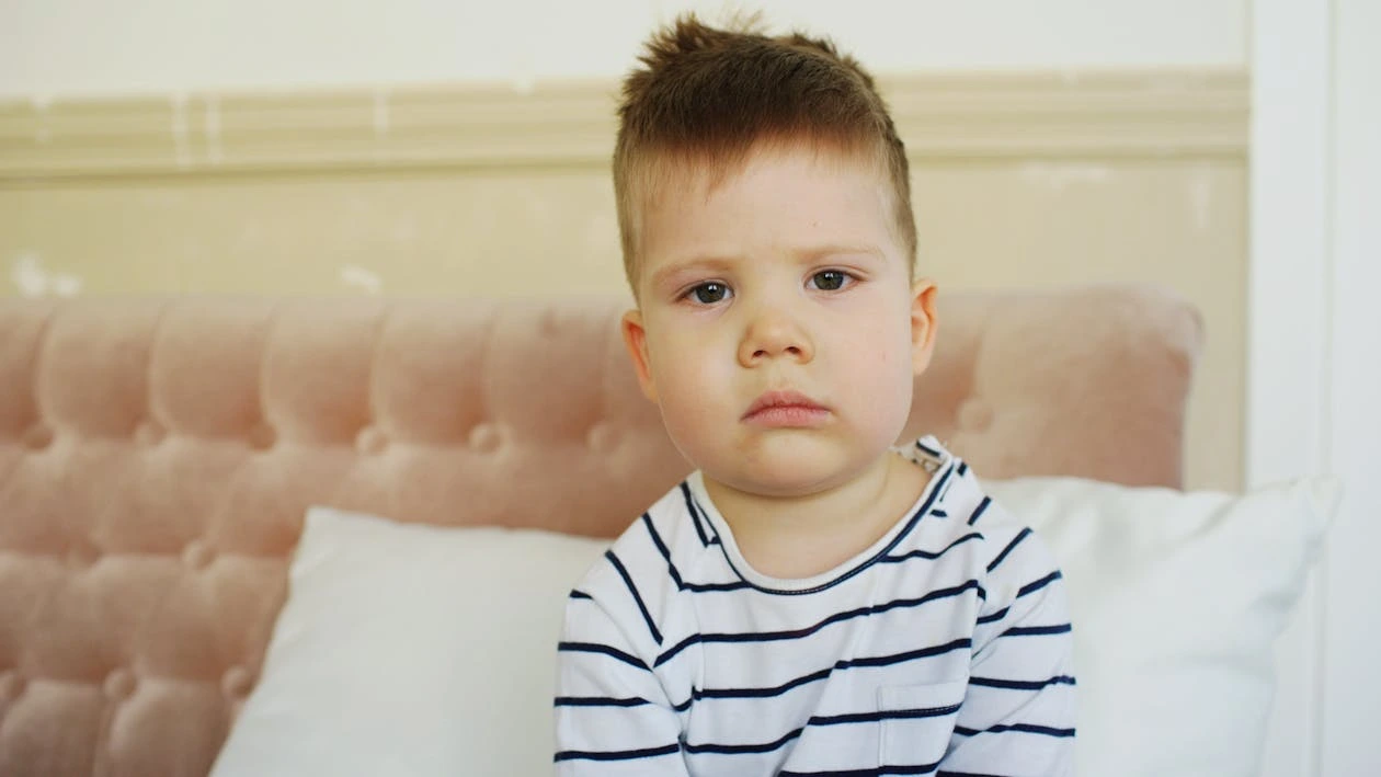 Sad boy sitting on a couch in a living room