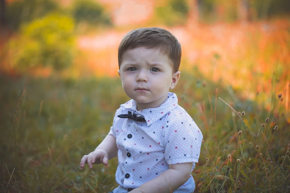Selective focus photography of a toddler wearing a white polo shirt