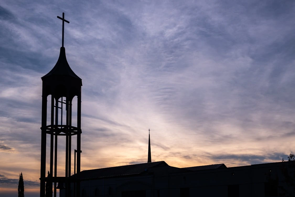 Silhouette of a church tower cross at sunset in Plano, Texas
