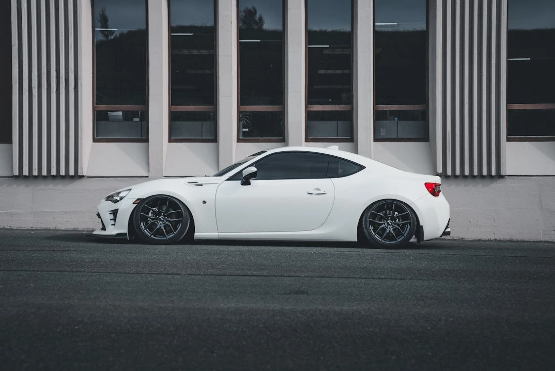 Sleek white sports car parked outside a modern building