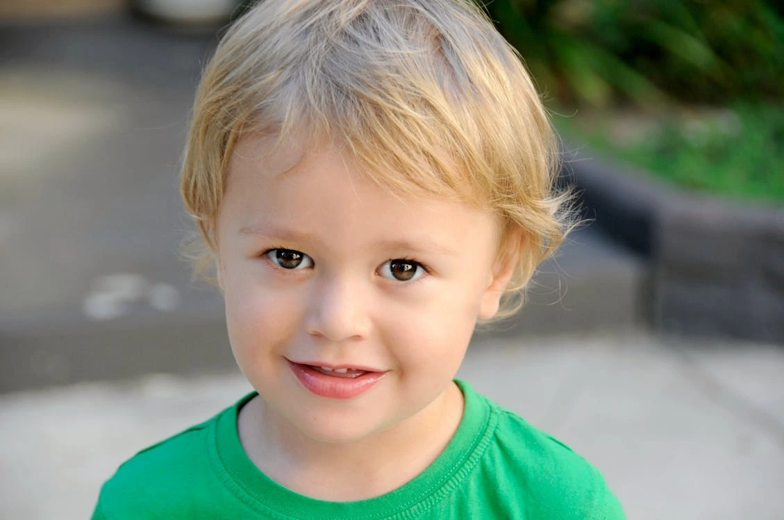 Smiling boy in a green crew neck top