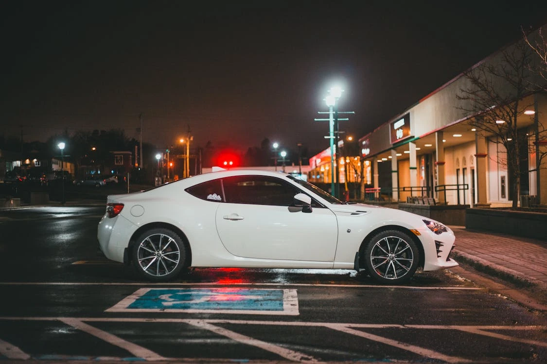 White car on asphalt near a building during evening time